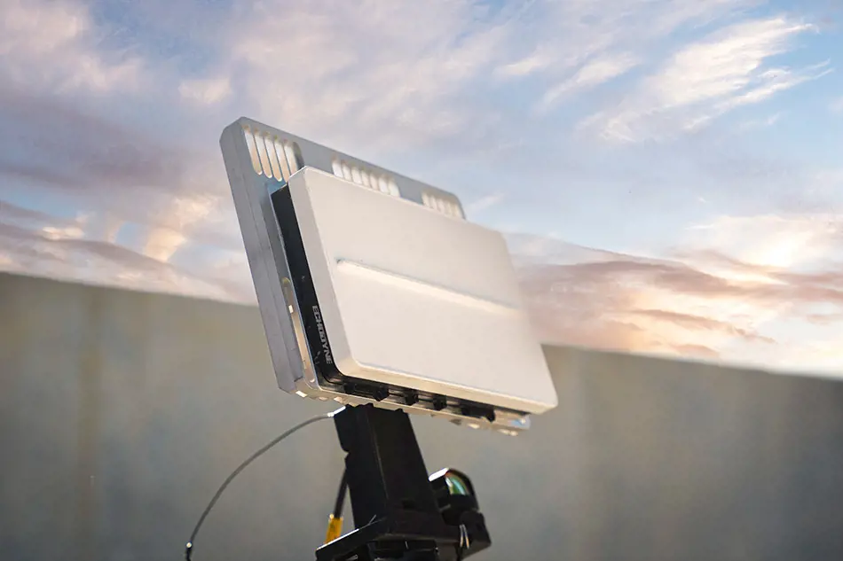 Grey vehicle with mounted EchoShield radars against a black background with grey hexagon pattern