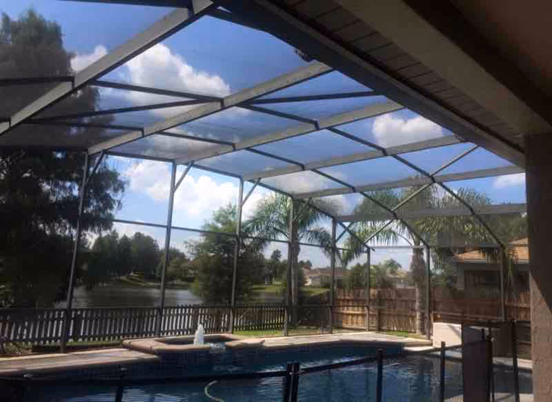 Screen enclosure cleaning service removing green algae buildup from pool cage mesh in Longwood Florida