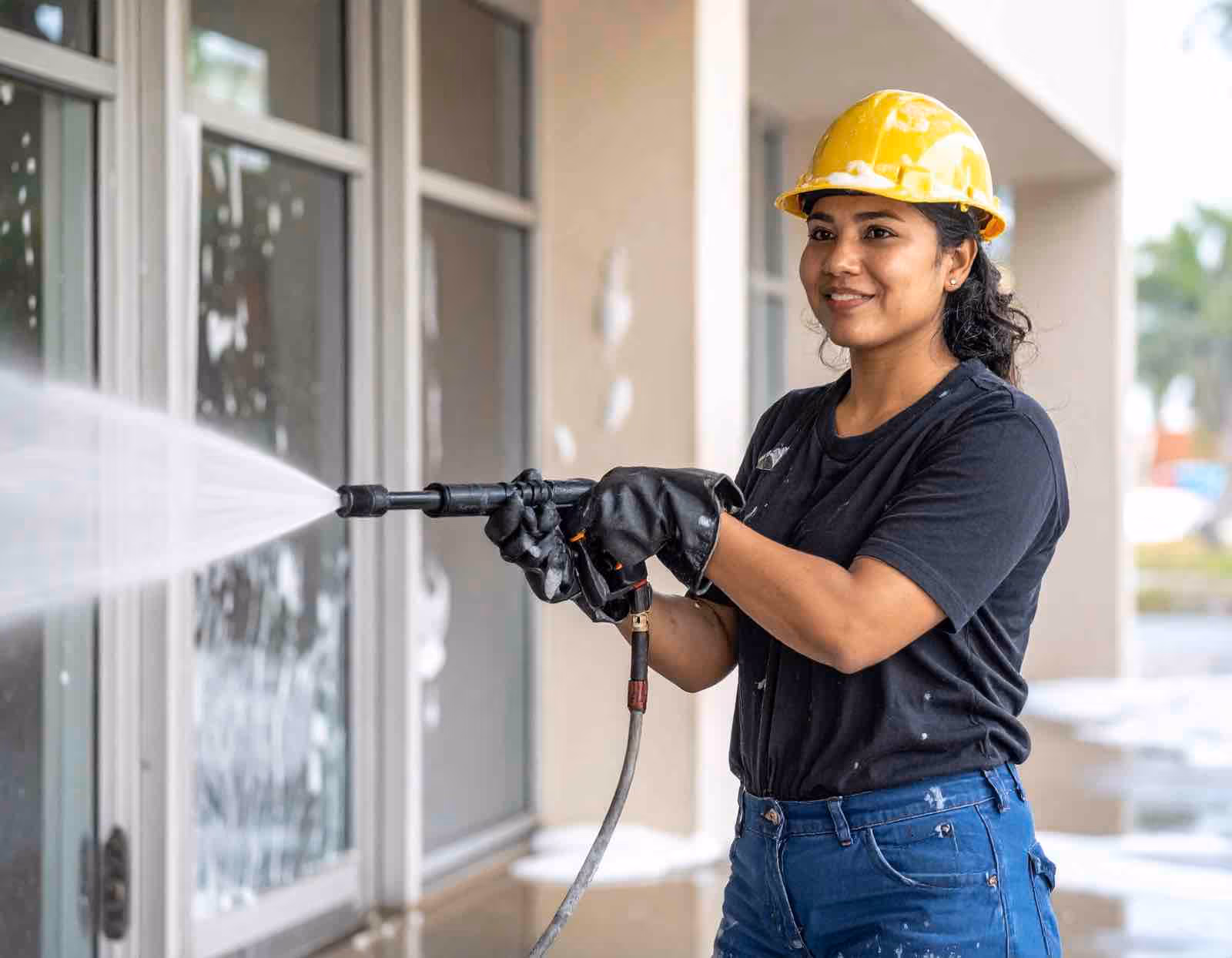 Technician performing school window cleaning using water-fed pole system on elementary school exterior glass