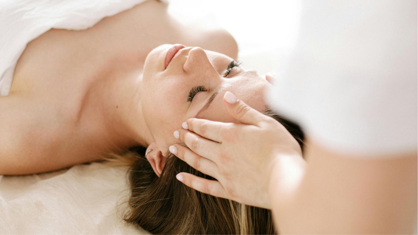 Une femme professionnelle prenant des notes tout en parlant avec un homme assis en face d'elle dans un bureau lumineux.