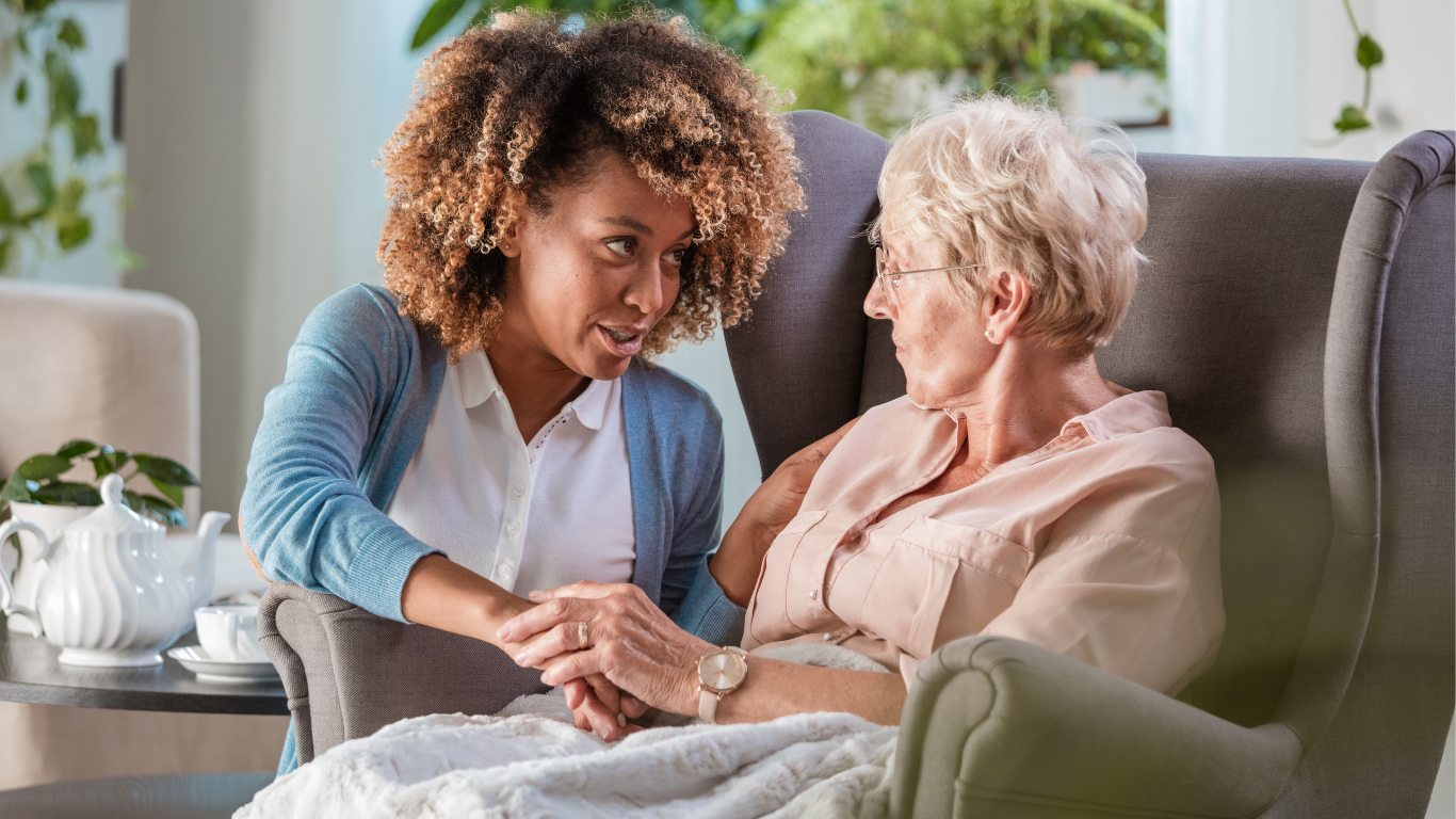Une professionnelle de santé effectue un étirement du cou sur une femme assise en blouse blanche.