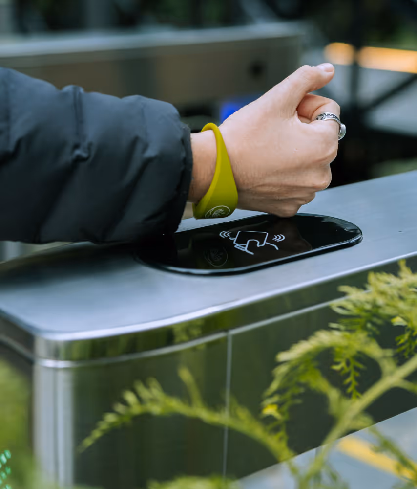 Usuario entrando con su pulsera por el pórtico automático.