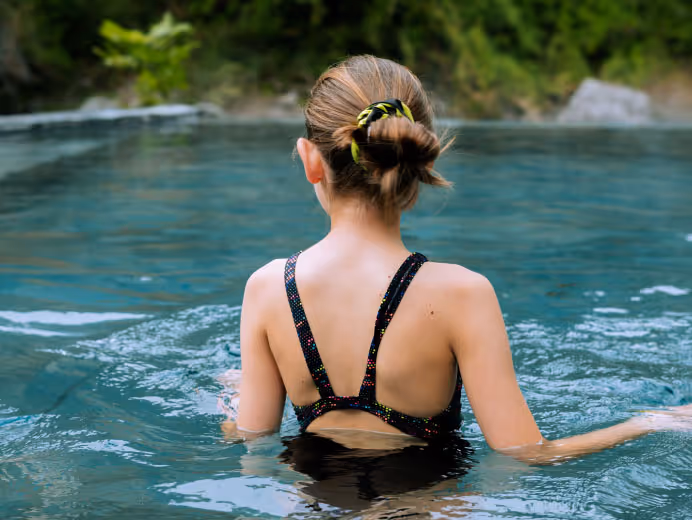 Niña relajada disfrutando de las aguas curativas y certificadas por el MINSAL