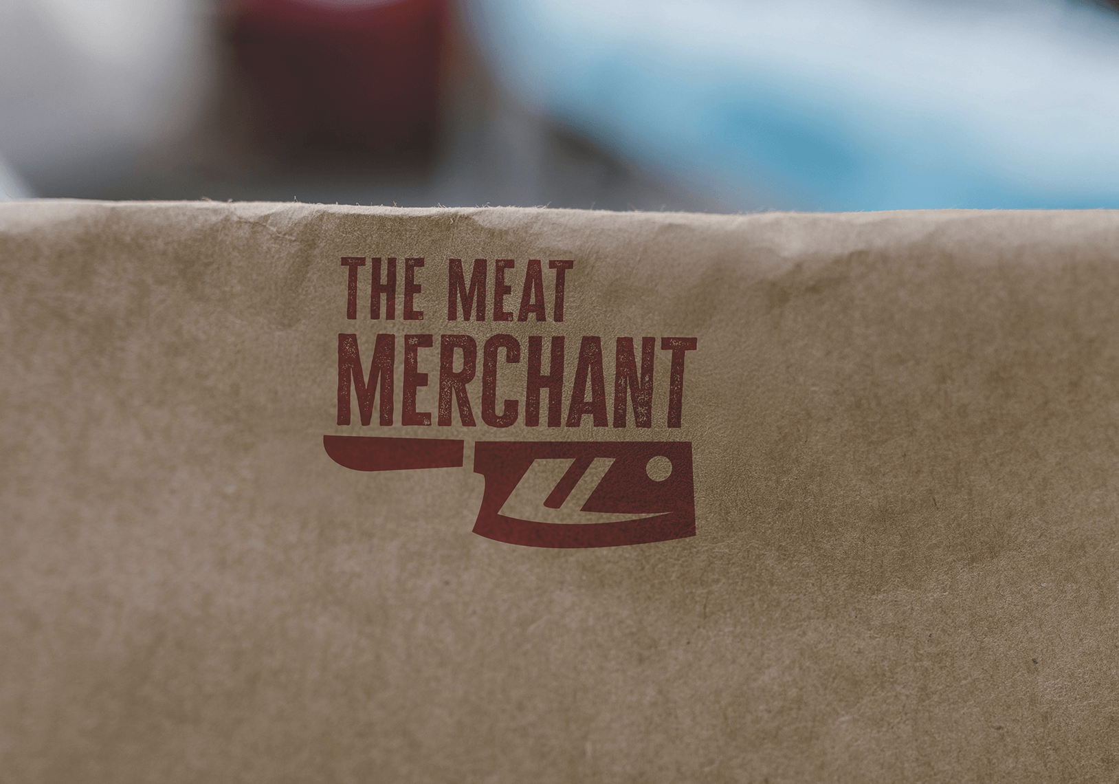 Brown paper package with the text 'The Meat Merchant' and a cleaver graphic.