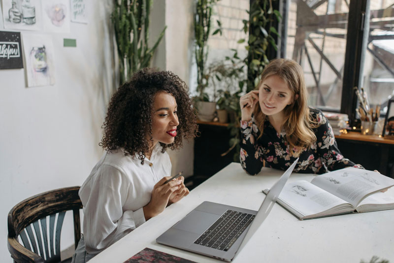 Two women looking a laptop computer