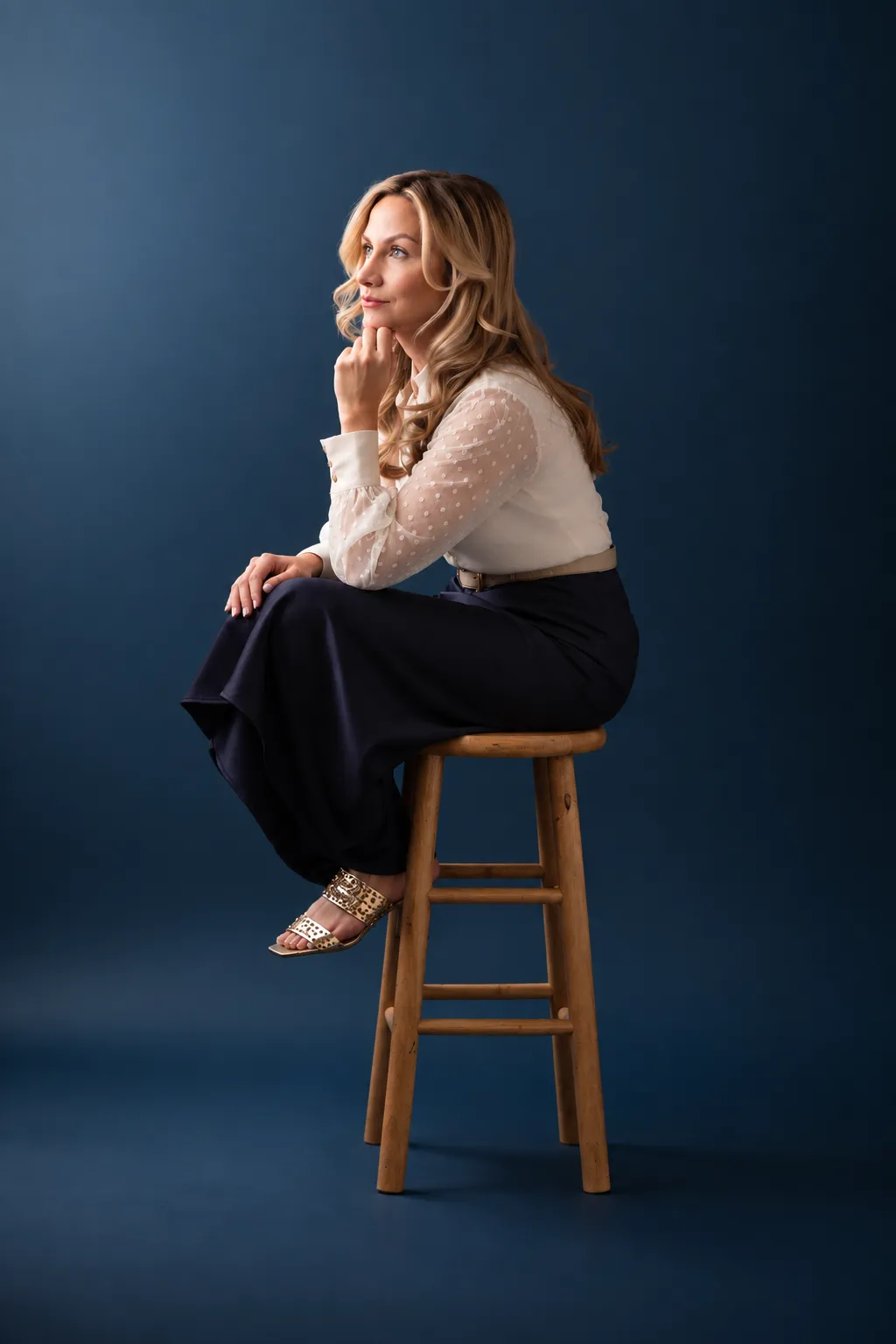 Christina Muller seated on a stool, deep in thought