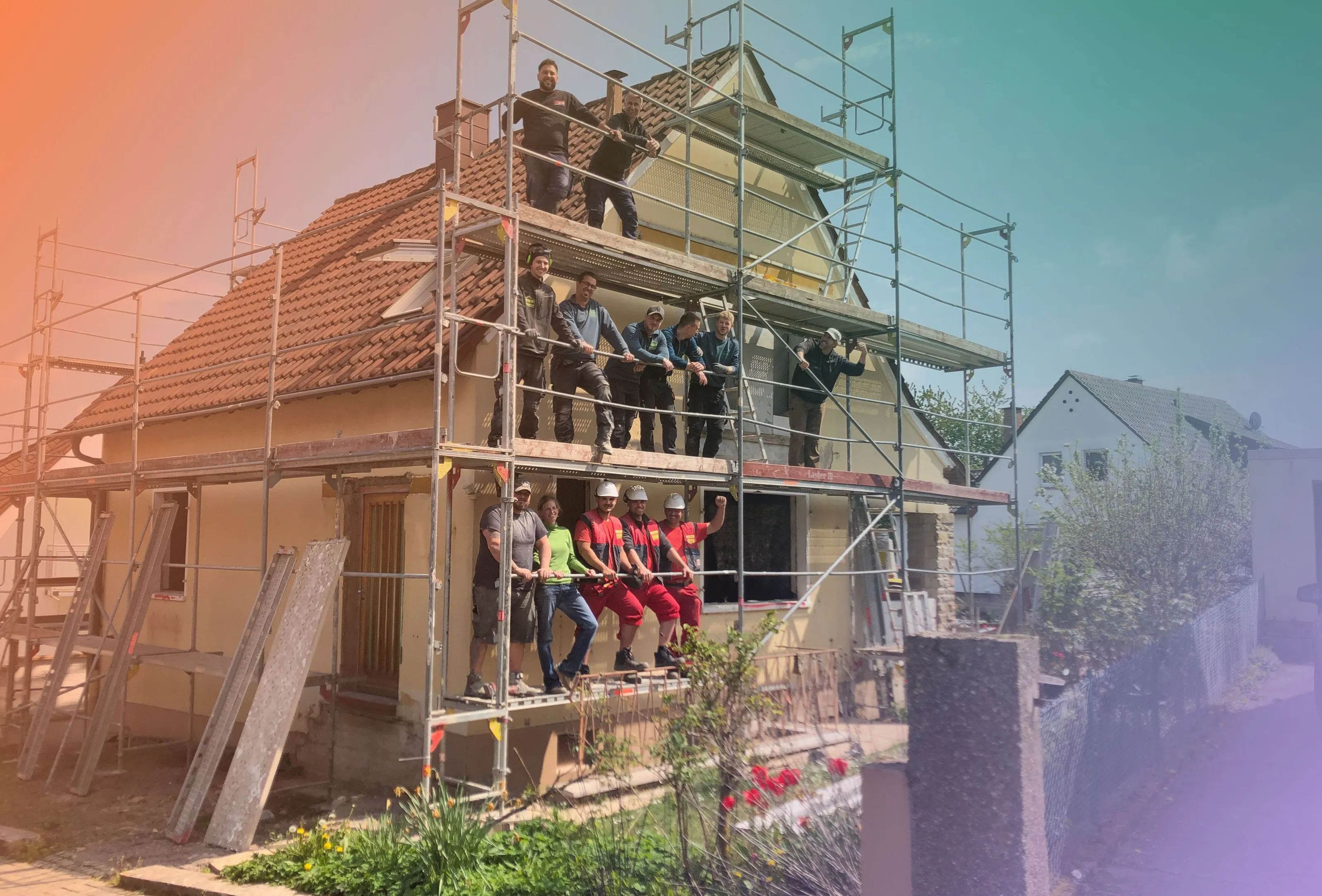 Handwerker auf Baugerüst an Haus bei Sonne.