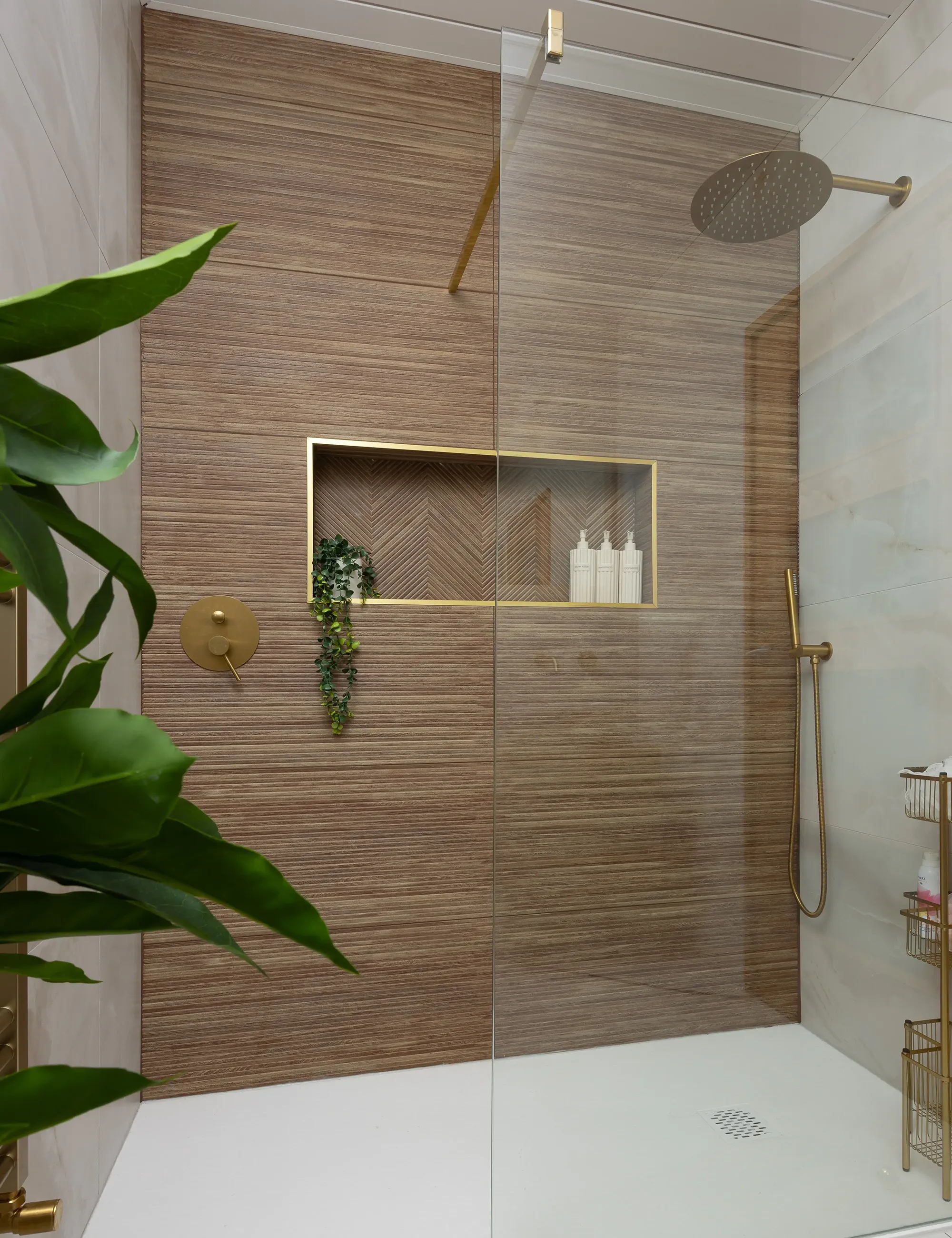 Modern wet room installation with walk in shower and golden details