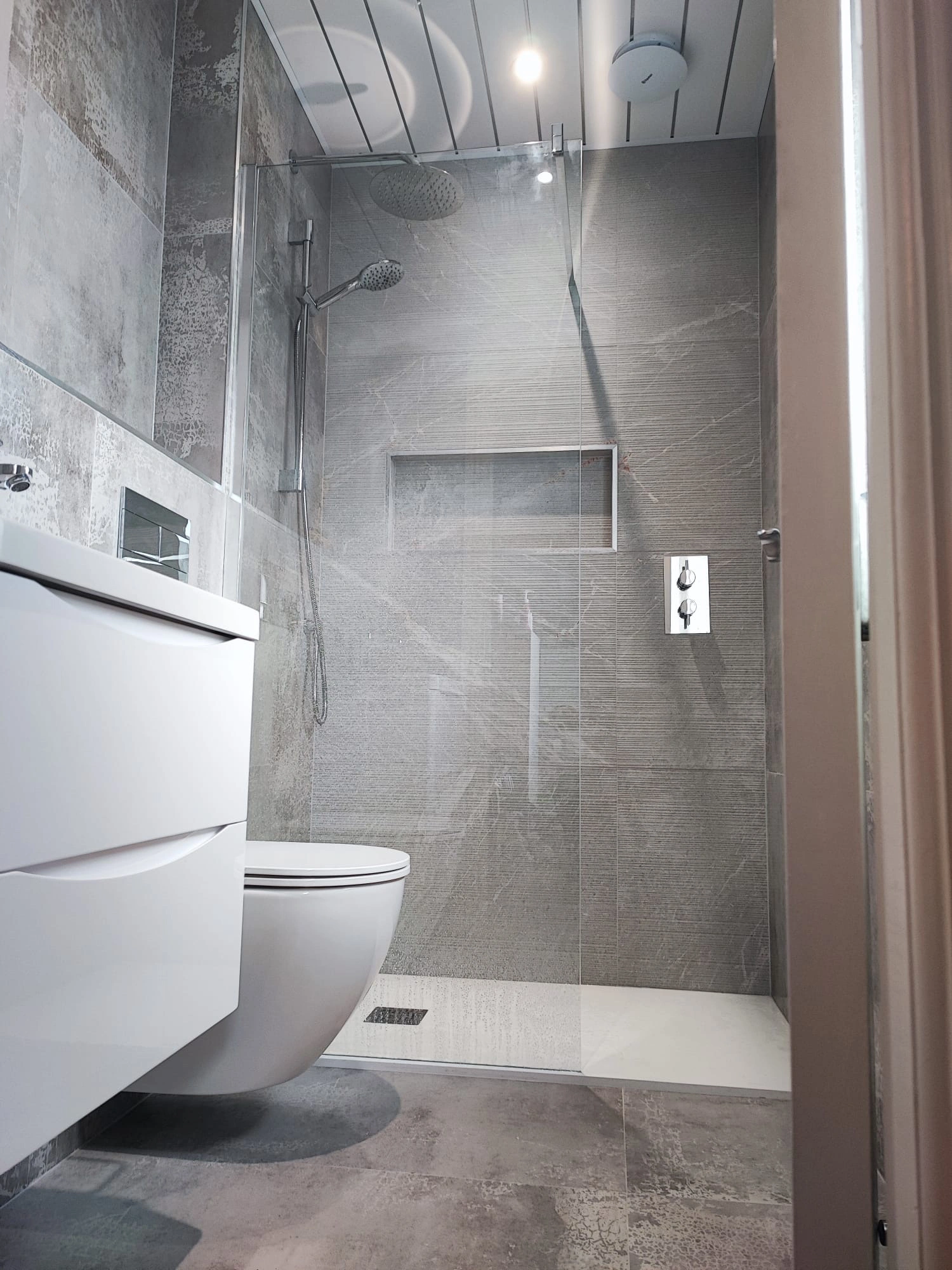 Walk in shower bathroom renovation with glass screen and grey tiles Ireland