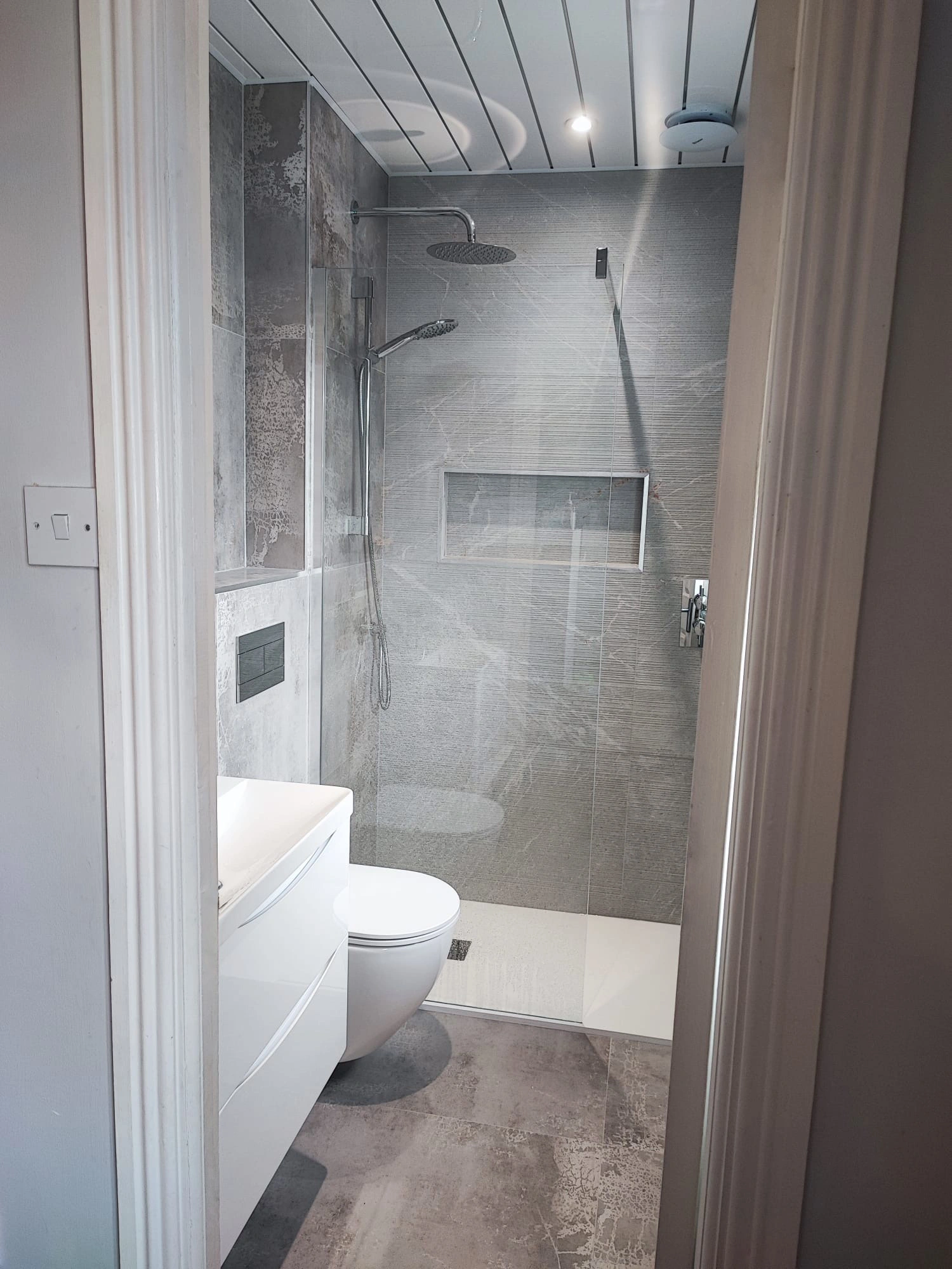 Walk in shower bathroom renovation with glass screen and grey tiles Ireland