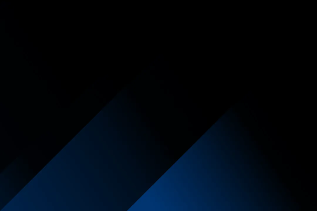 Abstract dark background with diagonal blue and black gradient shapes.