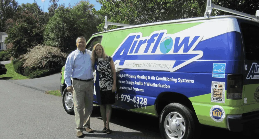 Two people standing beside a green and blue Airflow HVAC company van parked on a residential street.