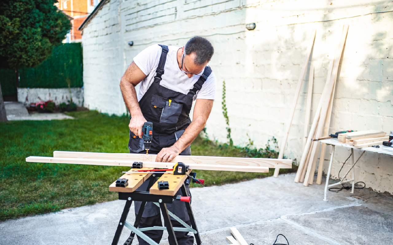 Man using a power saw at a workbench, representing handyman and home repair services.