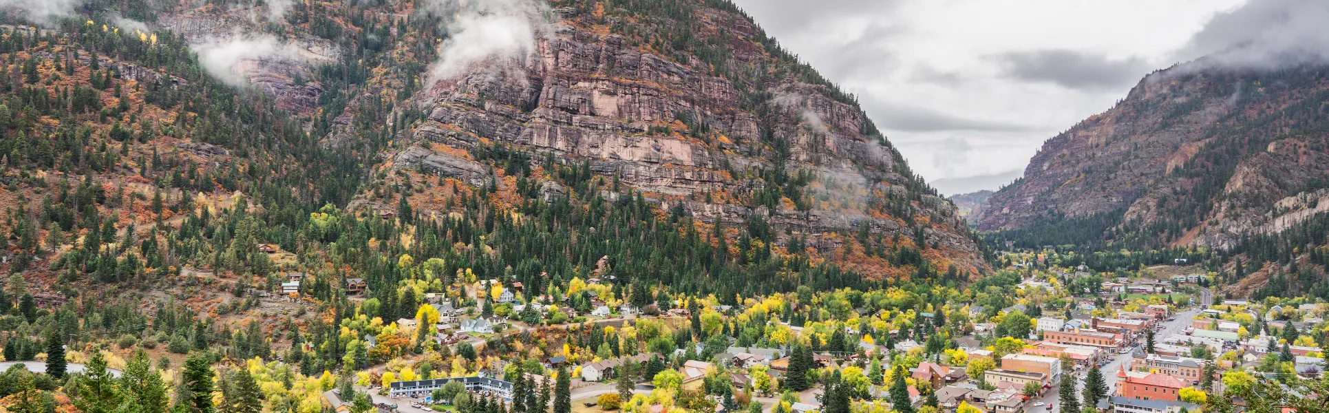 Scenic view of Ouray, Colorado surrounded by mountain cliffs and fall colors, representing Lucky Services' local home and rental support.