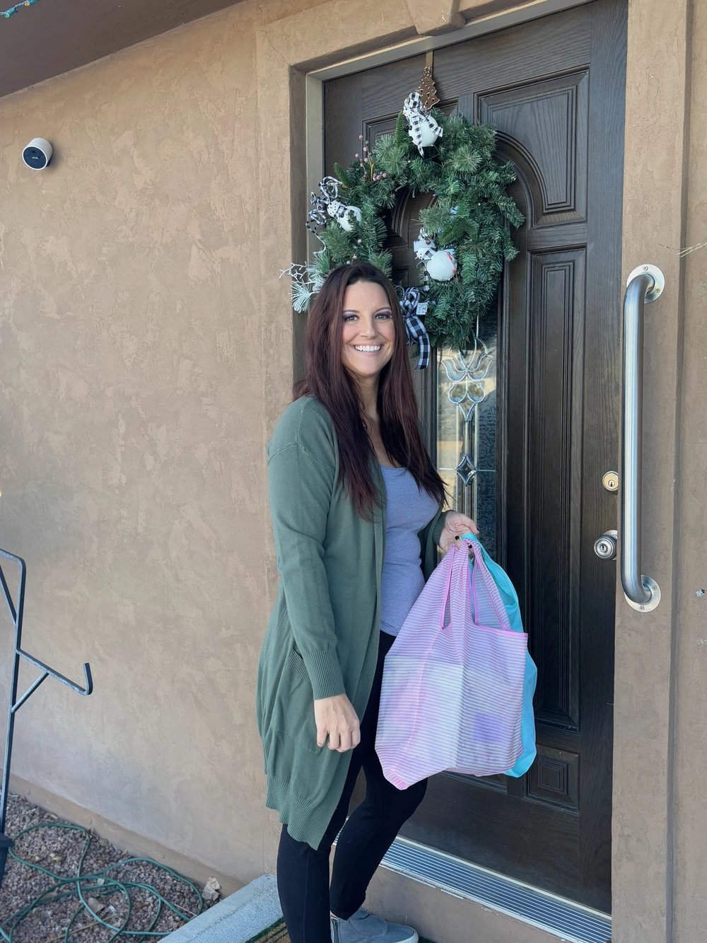A Lucky Services team member smiling while delivering packages to a home in Ridgway, Colorado, symbolizing friendly and reliable local service.