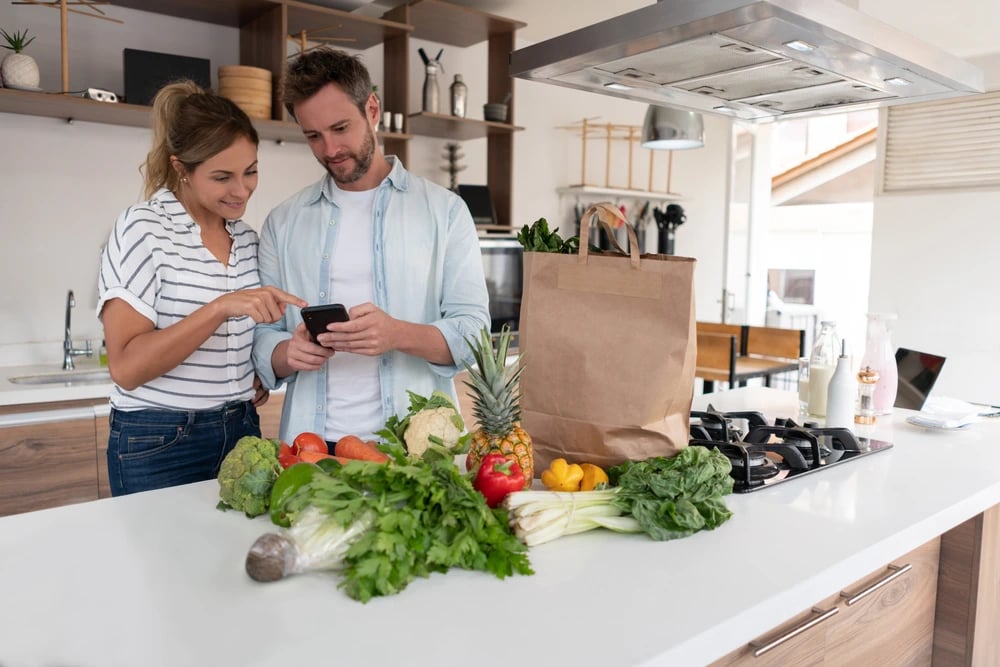 Couple unpacking fresh groceries in their kitchen, representing Lucky Services’ summer delivery, pet care, and short-term rental support in Durango.