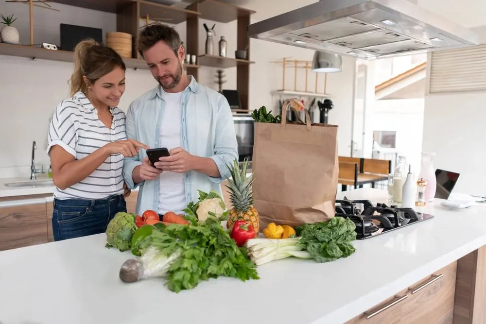 Couple unpacking fresh groceries in their kitchen, representing Lucky Services’ summer delivery, pet care, and short-term rental support in Durango.