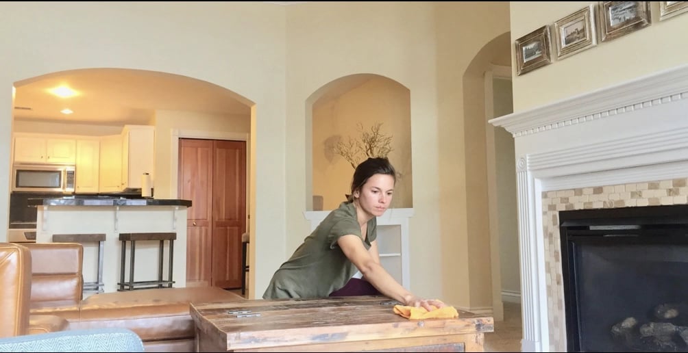 Person cleaning a Santa Fe home living room with eco-friendly supplies, representing Lucky Services’ professional residential cleaning.
