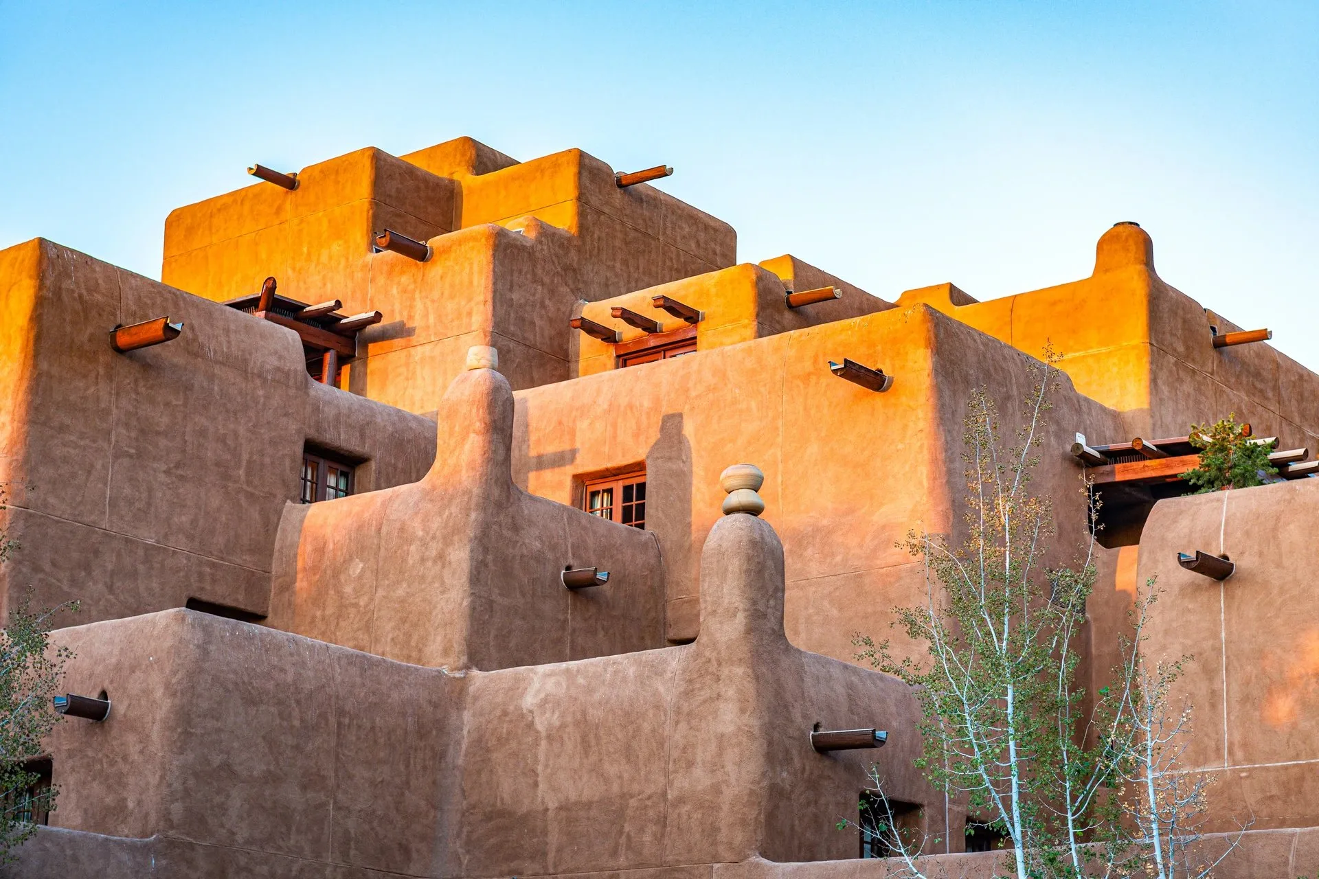 Adobe-style Pueblo Revival building in Santa Fe, New Mexico, photographed at sunset, representing Lucky Servicesâ home care and cleaning services for Santa Fe residents and vacation properties.