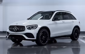 White Mercedes-Benz compact SUV parked indoors with black wheels.