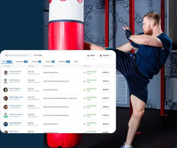 Man in blue athletic wear kicking a red and white punching bag in a gym.