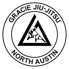 Gracie Jiu-Jitsu North Austin logo with a triangular emblem featuring two grappling figures inside.