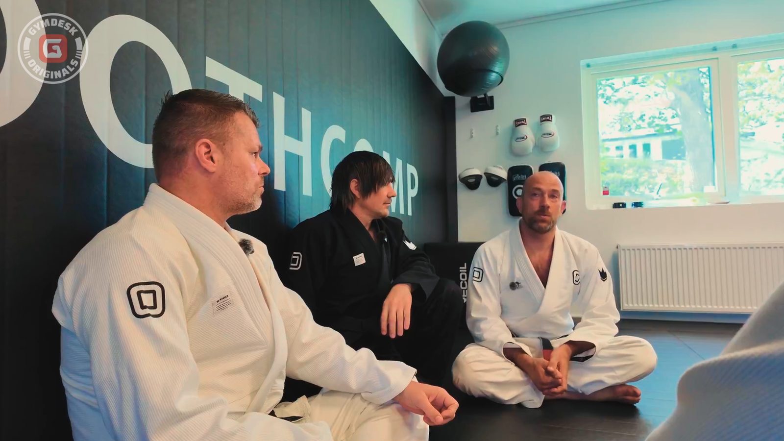 The Smoothcomp office, with gloves and pads on the wall behind the founders