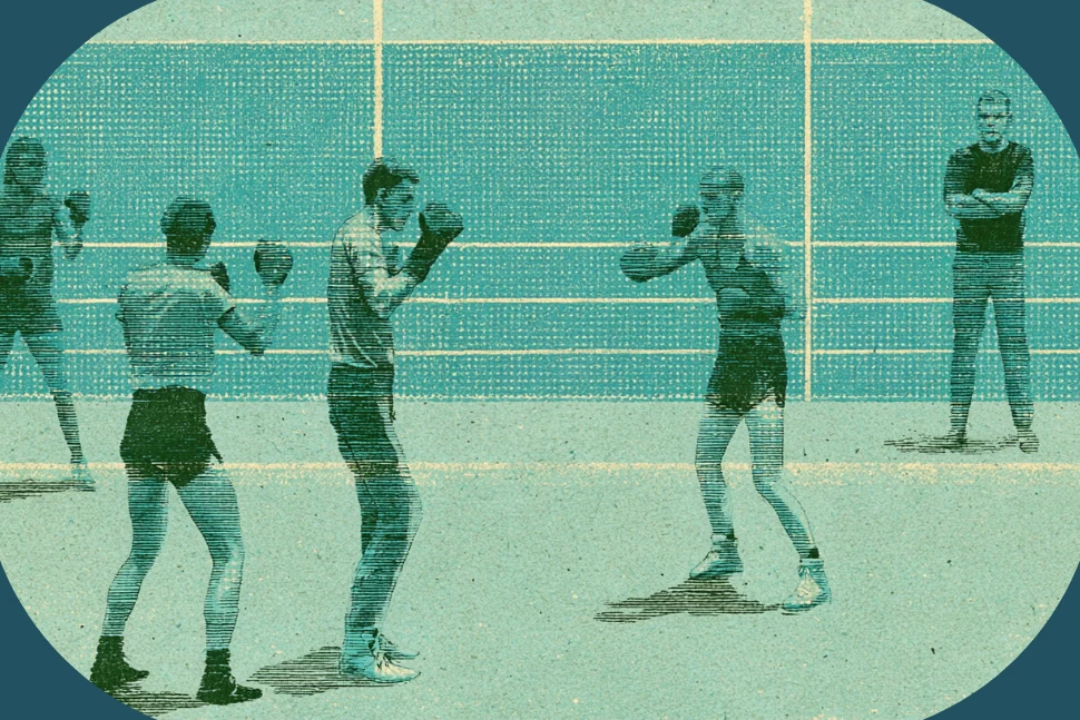 A boxing coach holding focus mitts for a beginner in a gym