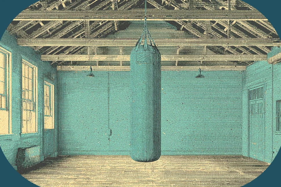 Heavy bag hanging from an exposed ceiling joist in a boxing gym