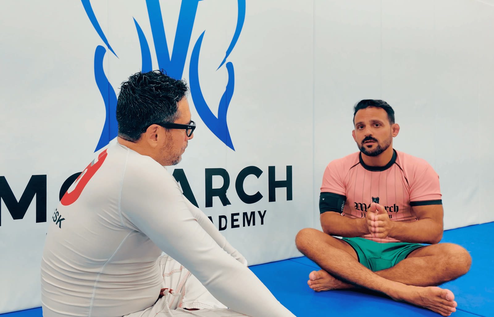 Alex Cuevas and Monarch owner Nick talking on the mat