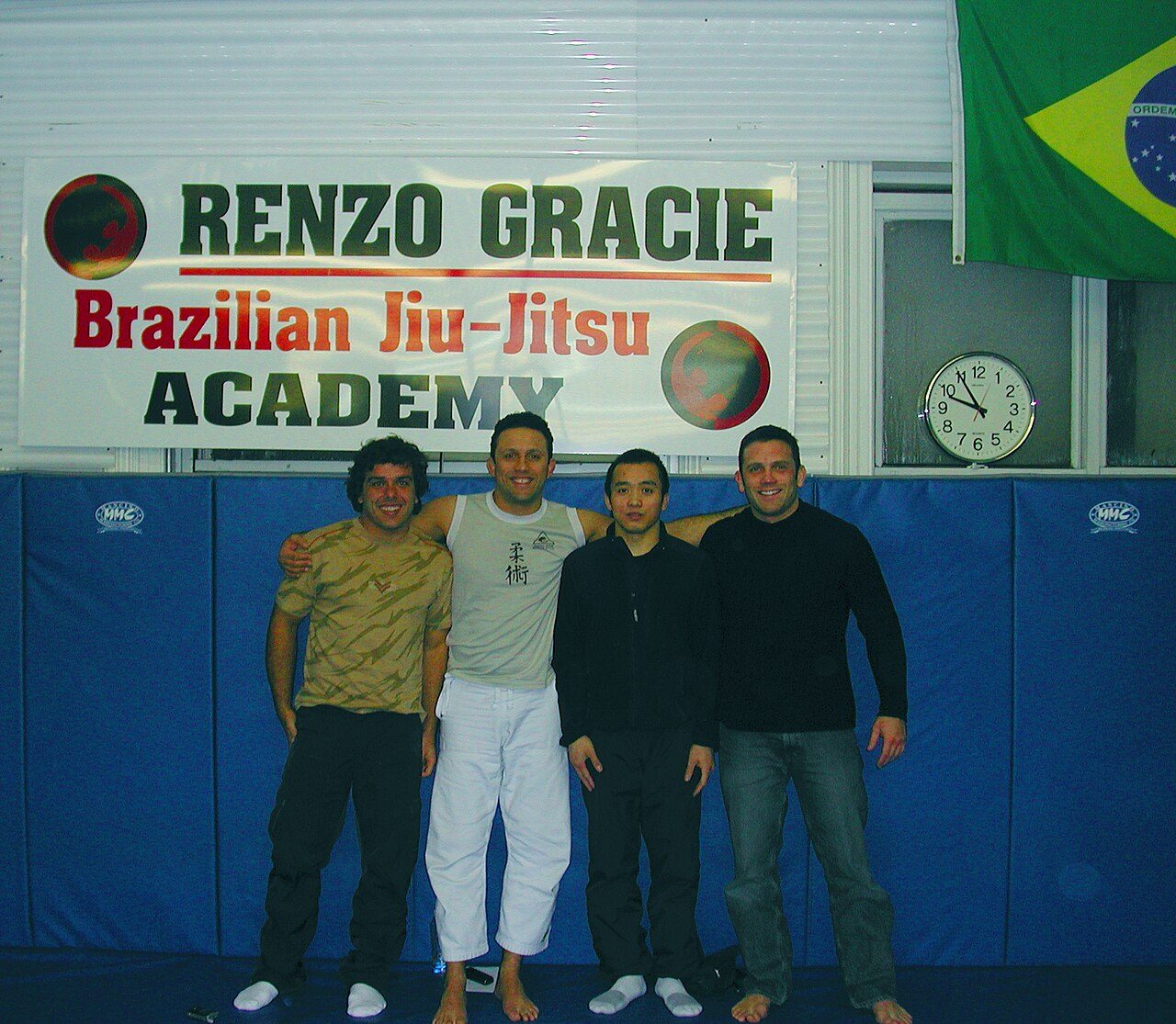 Renzo Gracie with students in front of the Renzo Gracie Brazilian Jiu-Jitsu Academy sign
