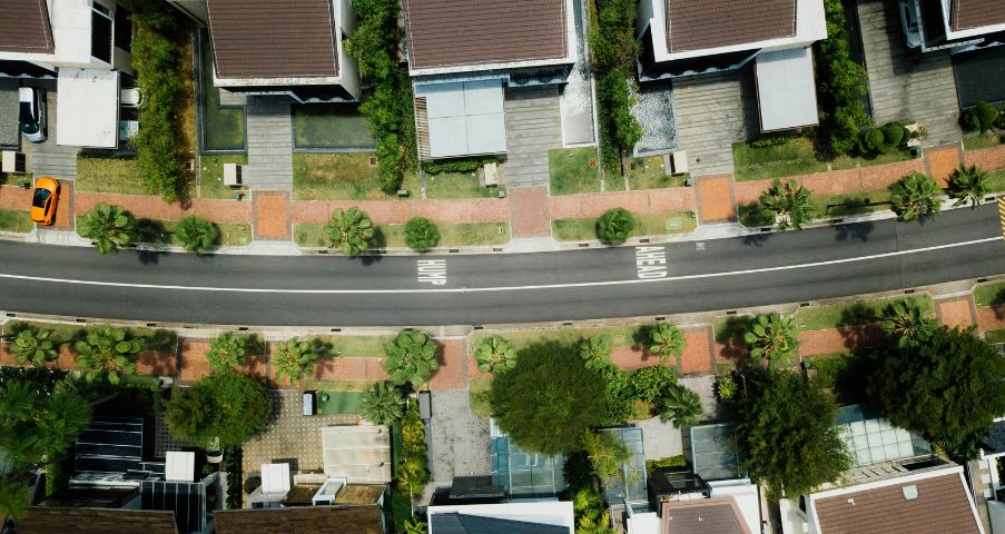 Aerial view of a suburban neighborhood with houses, roads, and trees.