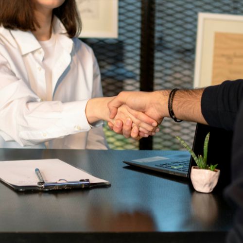 Handshake between agent and client during a real estate meeting.