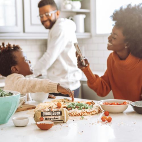 Family cooking together in a bright modern kitchen.