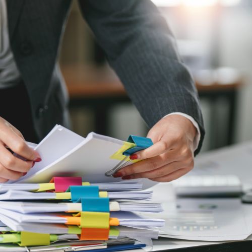 Professional organizing financial documents with sticky notes.