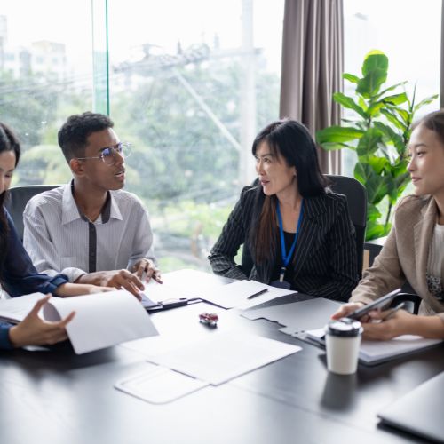 Team of real estate professionals discussing at a meeting table.