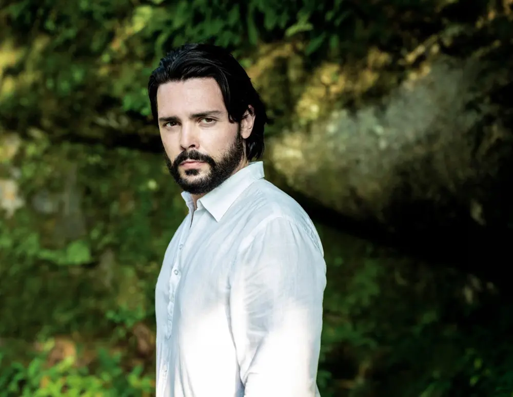 Image of Luca Micheletti photographed outside surrounded by greenery