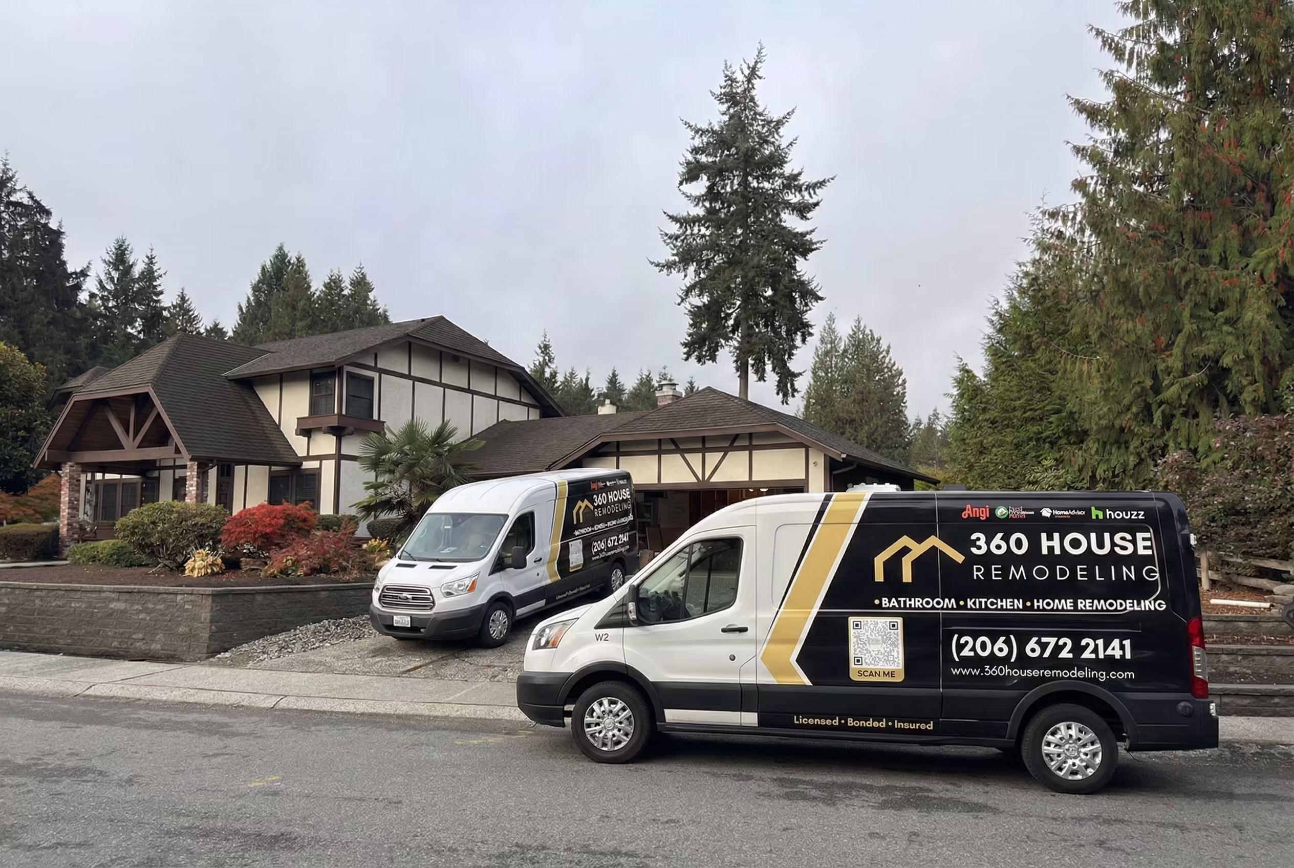 Two 360 House Remodeling vans parked on a residential driveway in front of a Tudor-style house surrounded by trees.