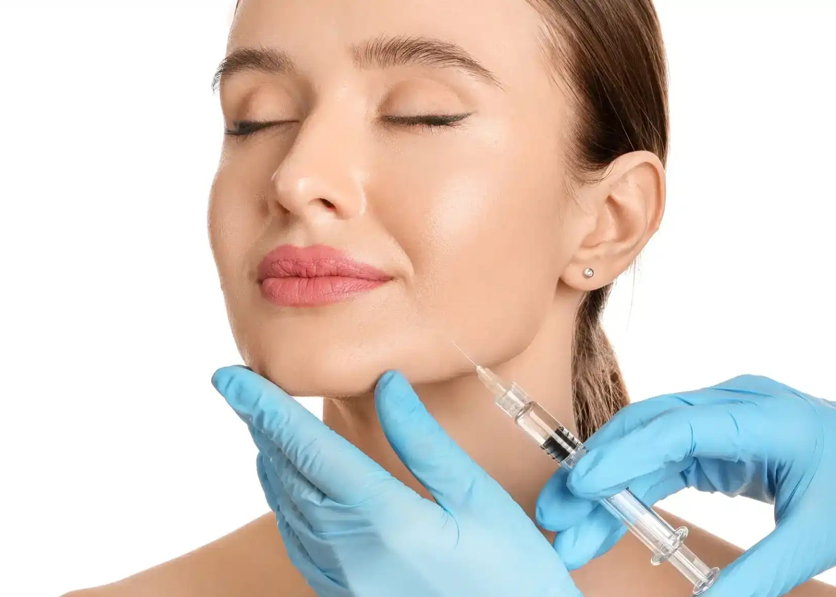 Close-up of a woman receiving a cosmetic injection in her chin from a gloved medical professional.