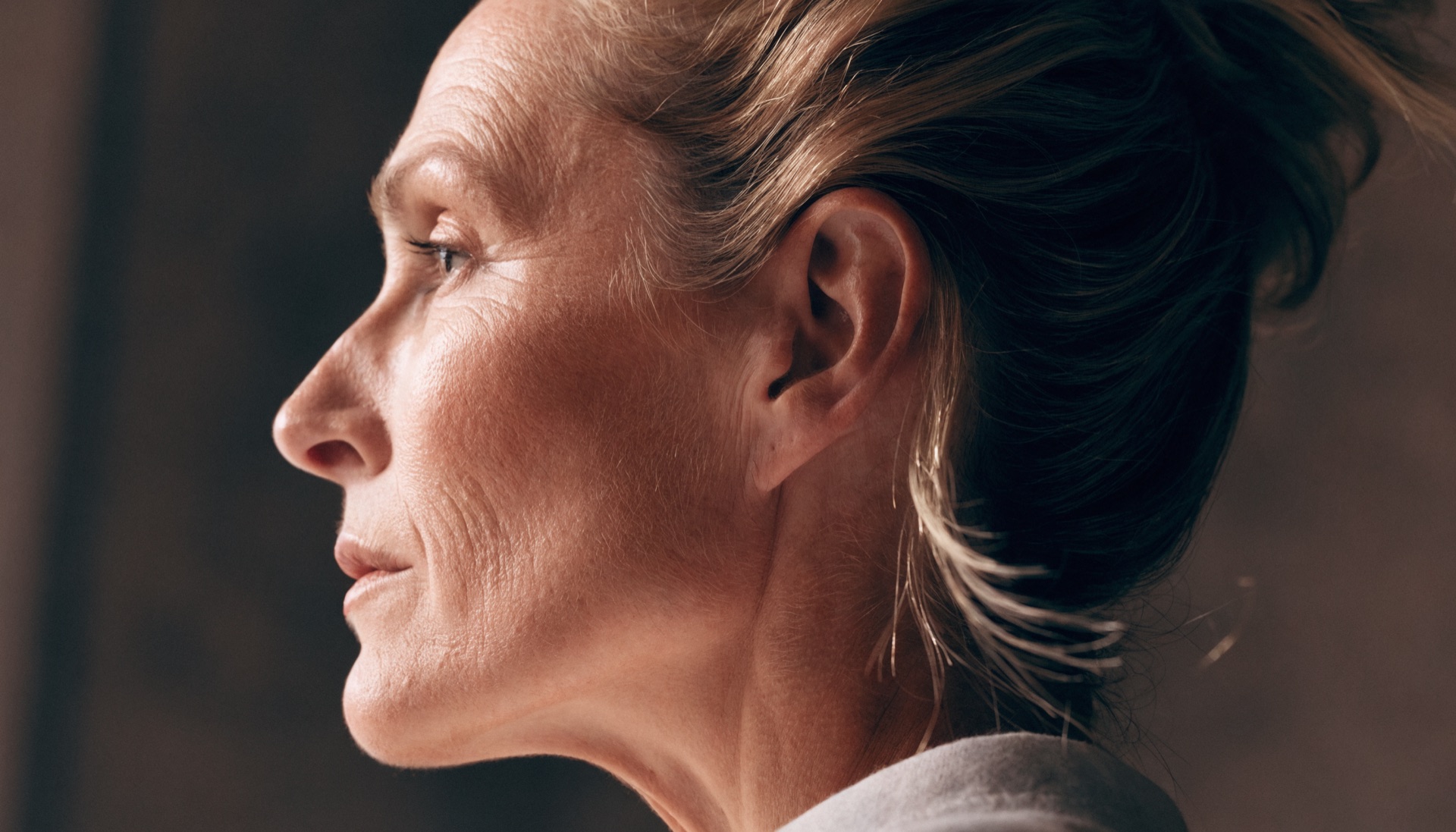 Profile portrait of a woman in her forties highlighting the jawline and neck in sculptural side lighting