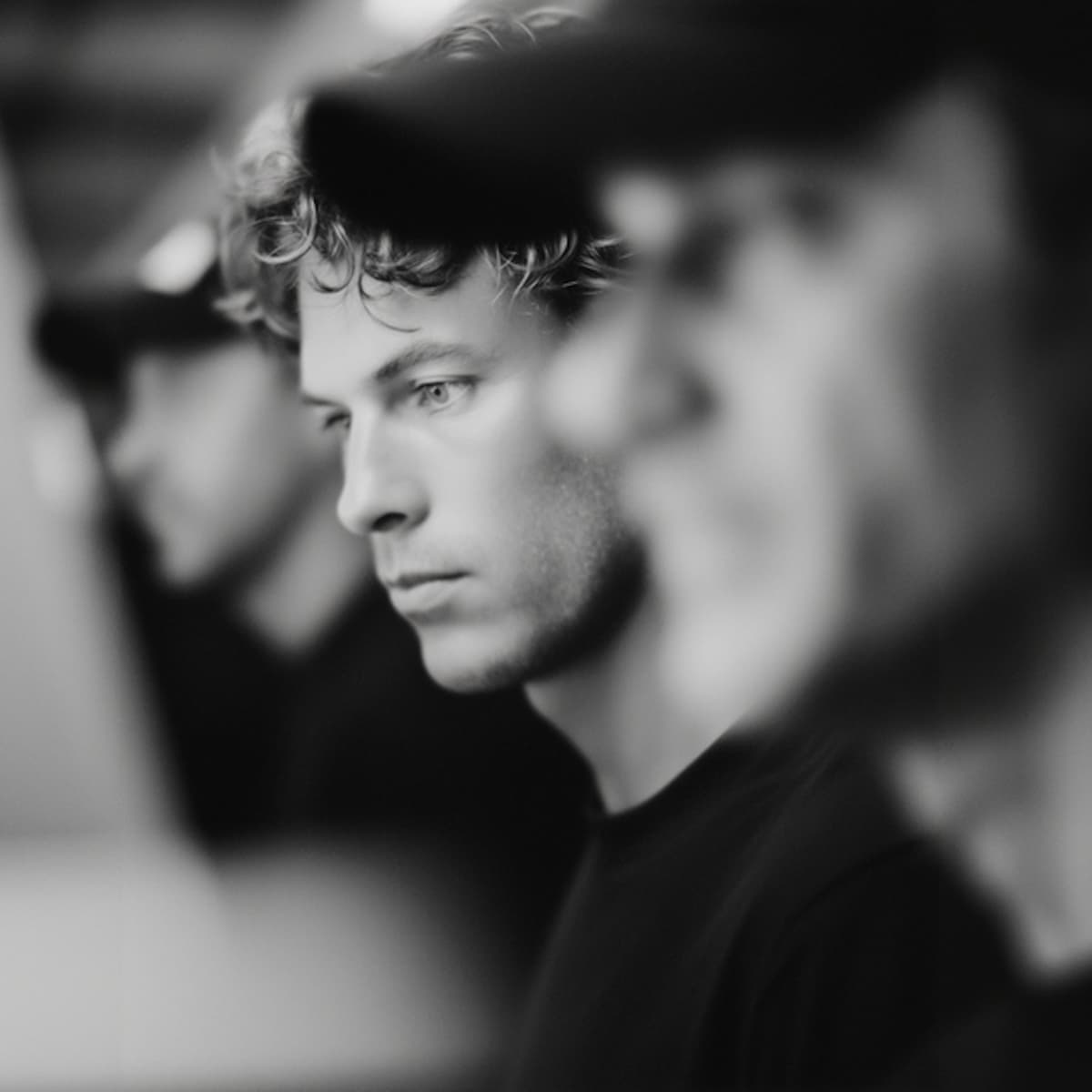 Team members working together in an office, with focus on a man in the middle.