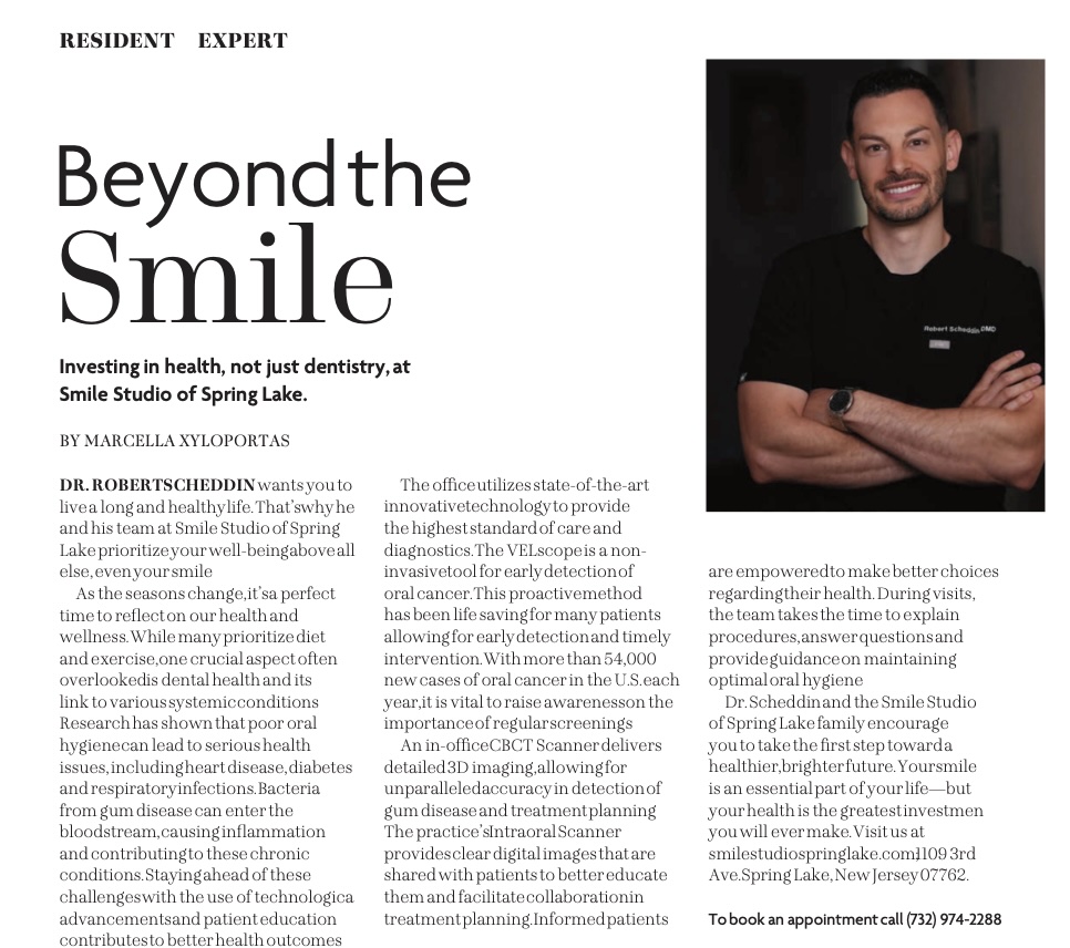 Portrait of Dr. Robert Scheddin in black scrubs, smiling with arms crossed against a dark background.
