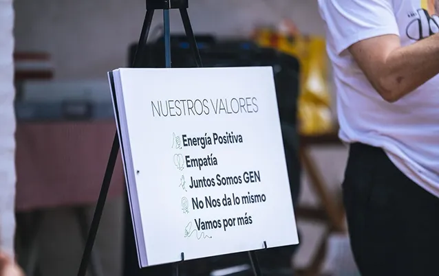 Whiteboard on a tripod listing core values in Spanish: Energía Positiva, Empatía, Juntos Somos GEN, No Nos da lo mismo, Vamos por más.