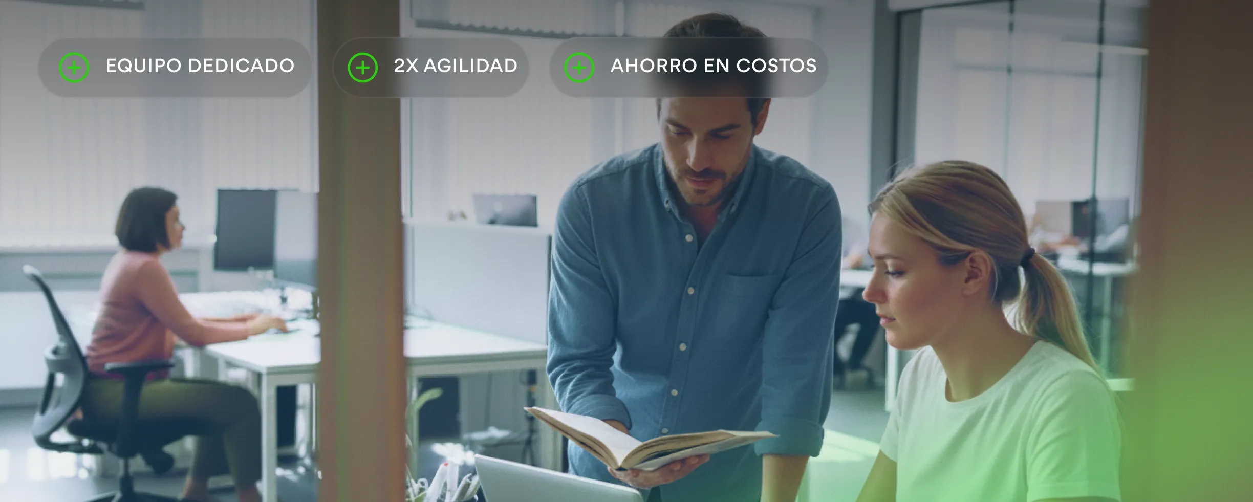 Two men working together at a computer in an office with a large window and cityscape view.