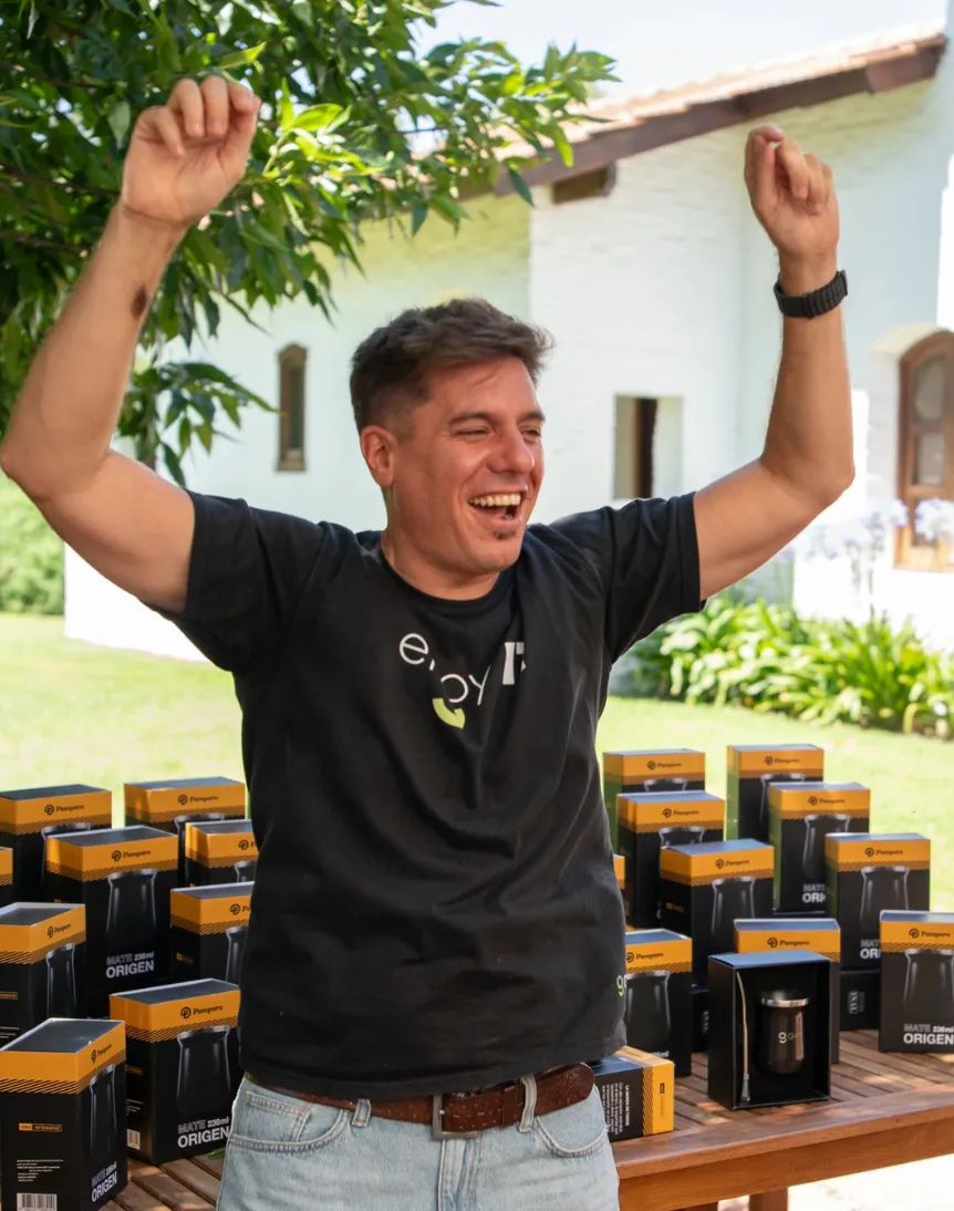 Two young adults collaborating in front of a glass wall covered with orange, blue, and white sticky notes, discussing ideas.