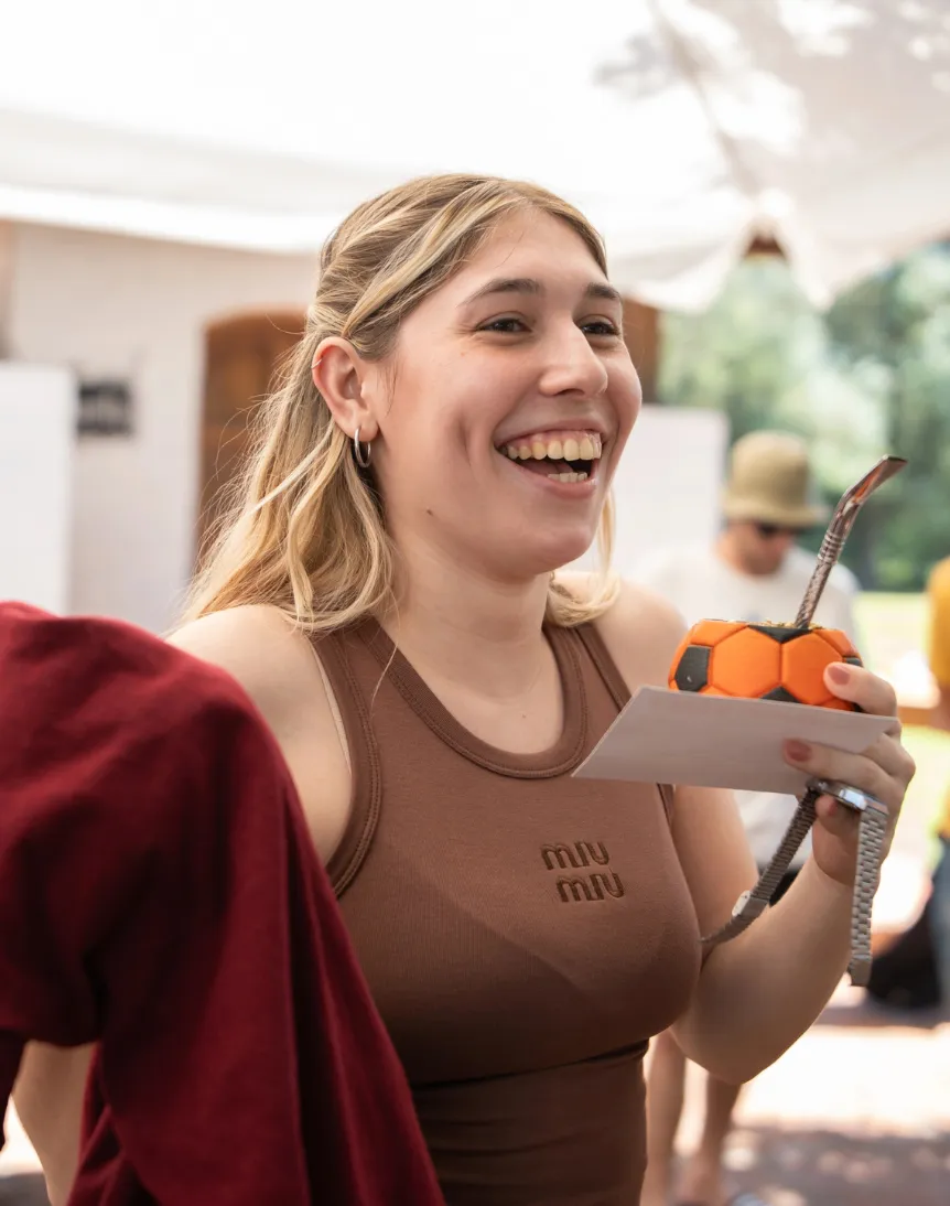 Three young men in black 'enjoy IT' shirts celebrate with a high-five and applause in a modern office setting.
