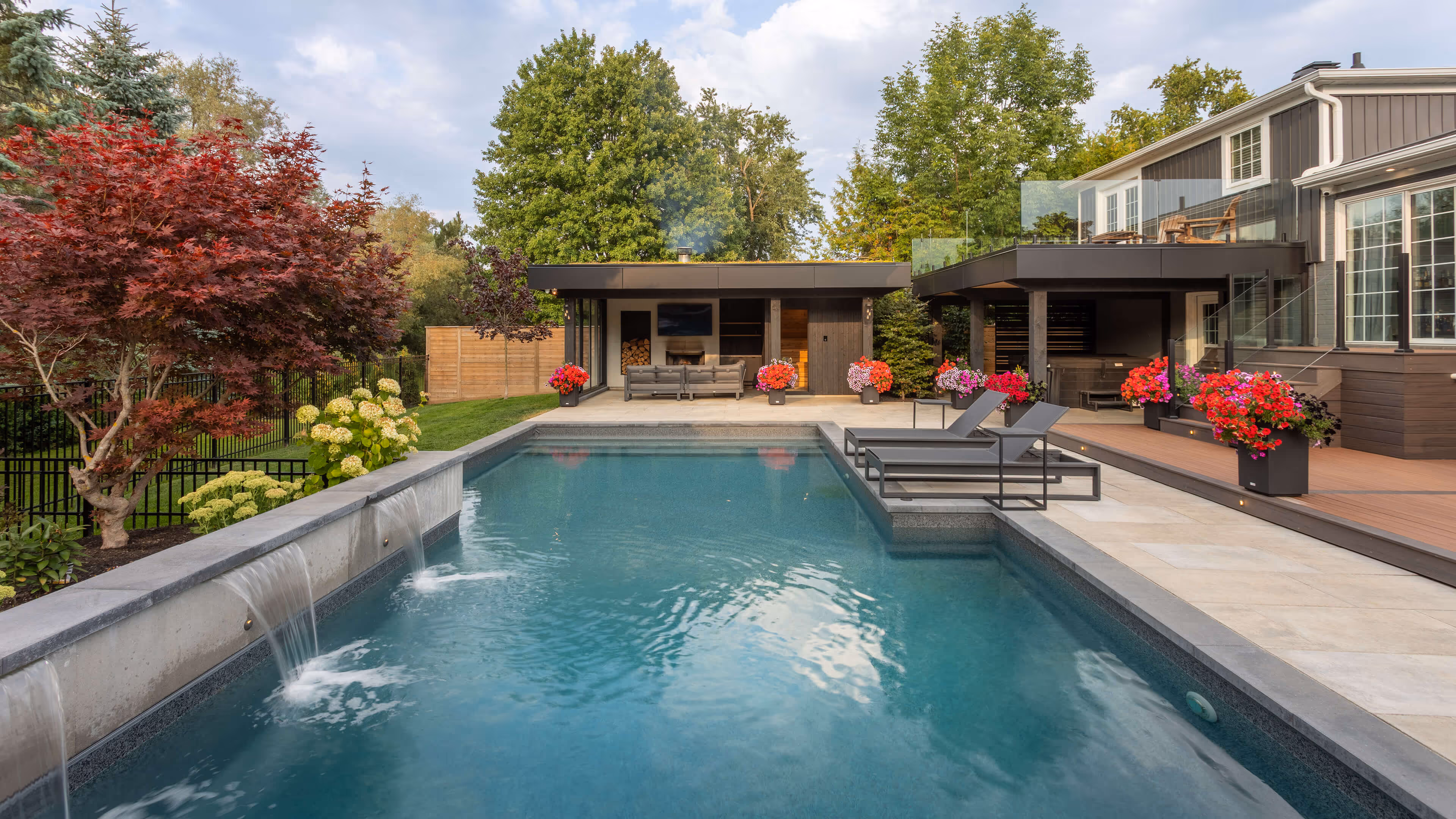 backyard landscaping with pool featureing waterfalls flowing into the pool, cabana with fireplace