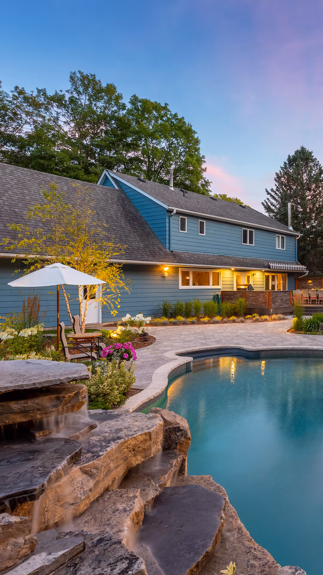 backyard landscaping with pool featureing waterfalls flowing into the pool, cabana with fireplace