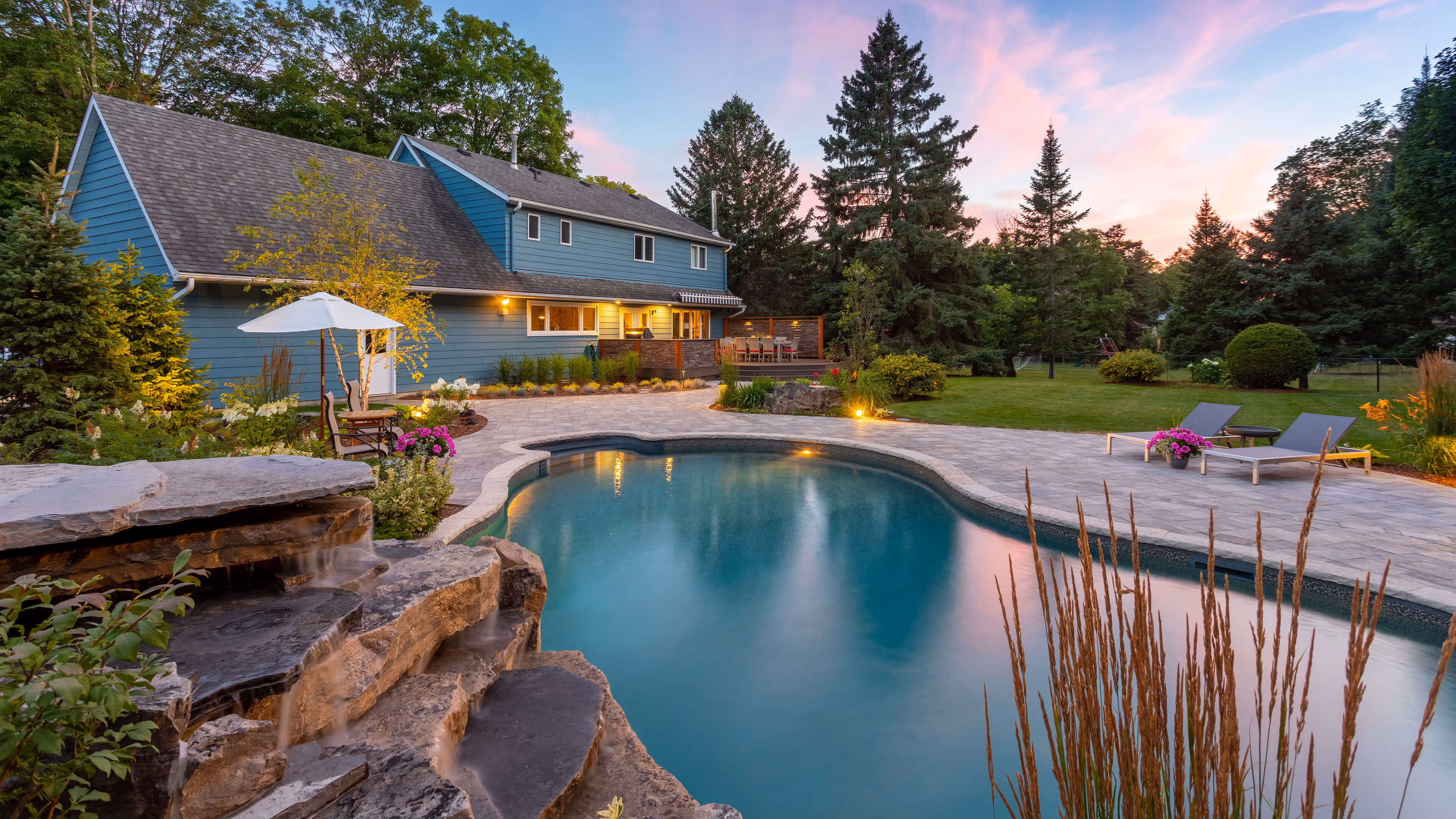 backyard landscaping with pool featureing waterfalls flowing into the pool, cabana with fireplace
