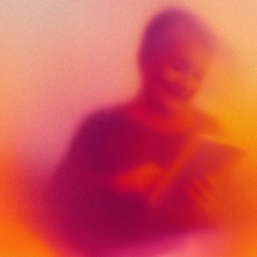 Blurred image of a person smiling and using a tablet, with warm purple and orange tones.